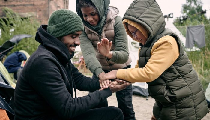 man-playing-with-kids-in-refugee-camp